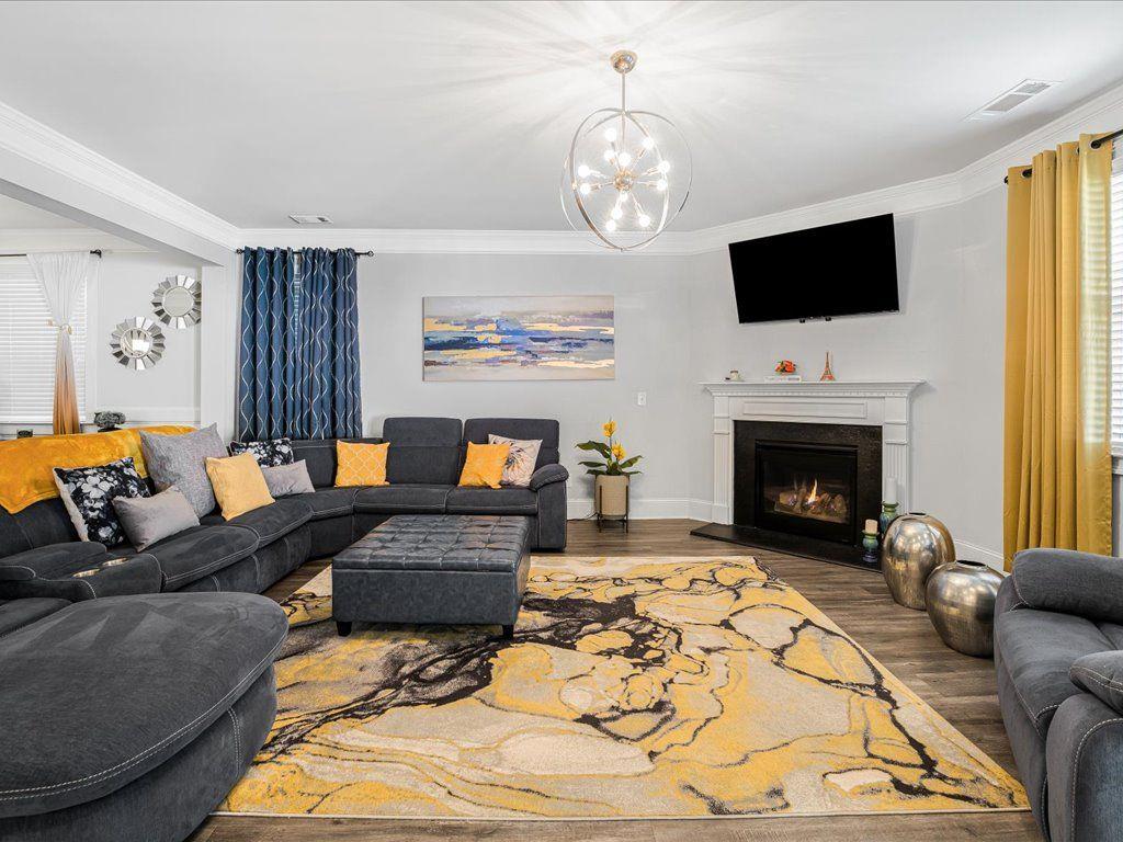 7675 Volion Drive Fairburn, GA 30213 - Photo 22 of 44 a living room with furniture a fireplace and a flat screen tv