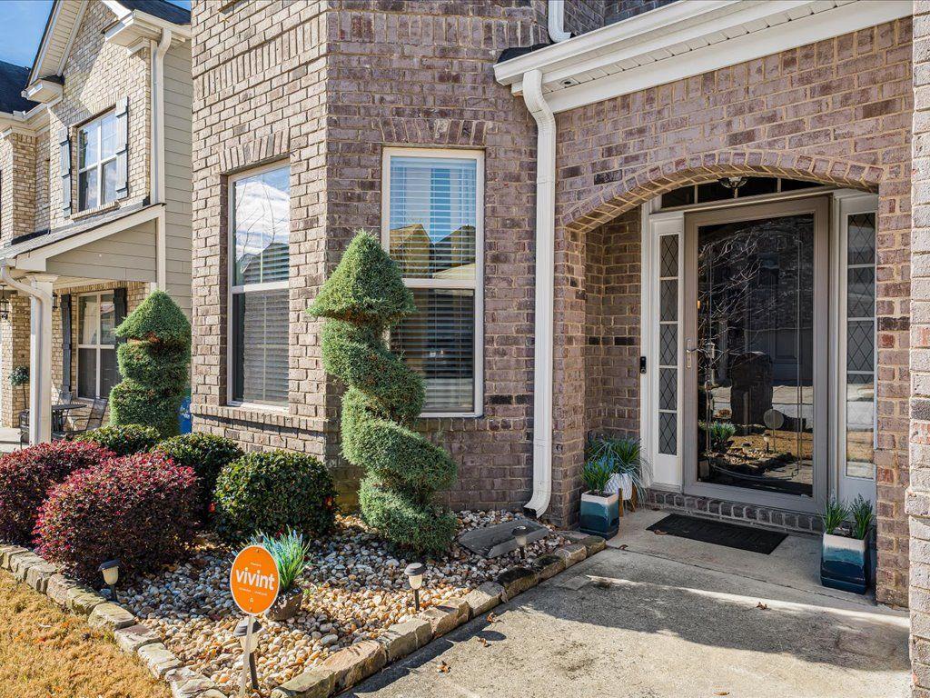 7675 Volion Drive Fairburn, GA 30213 - Photo 34 of 44 a view of brick house with potted plants and a bench