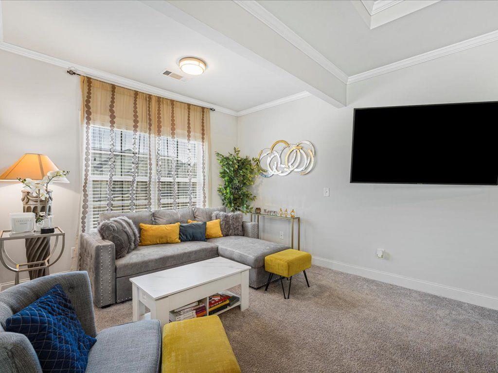 7675 Volion Drive Fairburn, GA 30213 - Photo 36 of 44 a living room with furniture and a flat screen tv