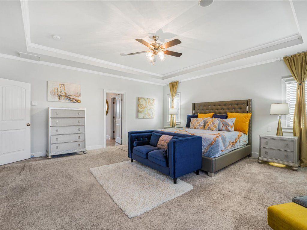 7675 Volion Drive Fairburn, GA 30213 - Photo 38 of 44 a bedroom with a large bed and a chandelier