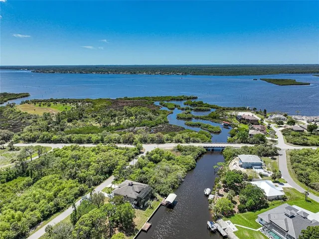 an aerial view of ocean and residential houses with outdoor space