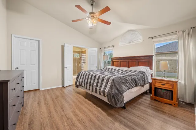 a bedroom with a large bed and a chandelier