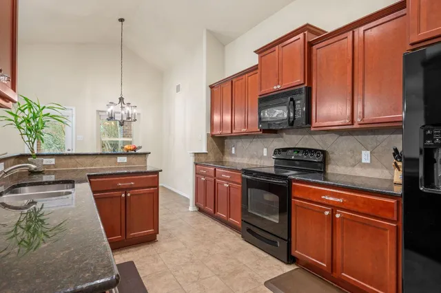 a kitchen with stainless steel appliances granite countertop a stove a sink dishwasher and microwave oven