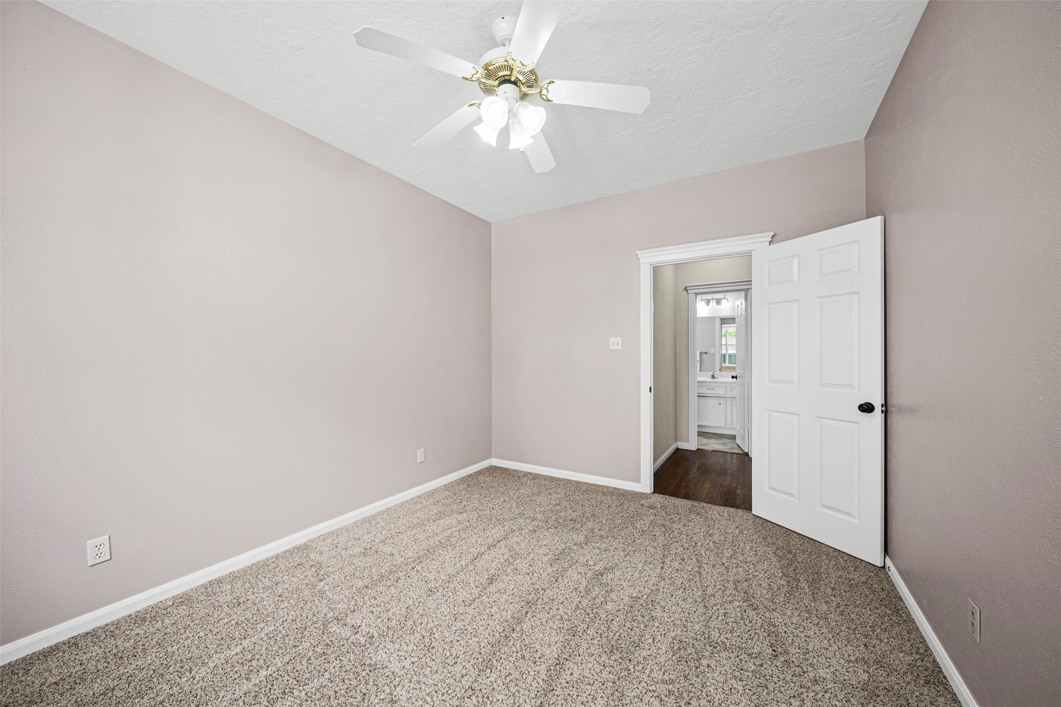 2452 Ripplewood Drive Conroe, TX 77384 - Photo 22 of 31 a view of a room with a ceiling fan and carpet