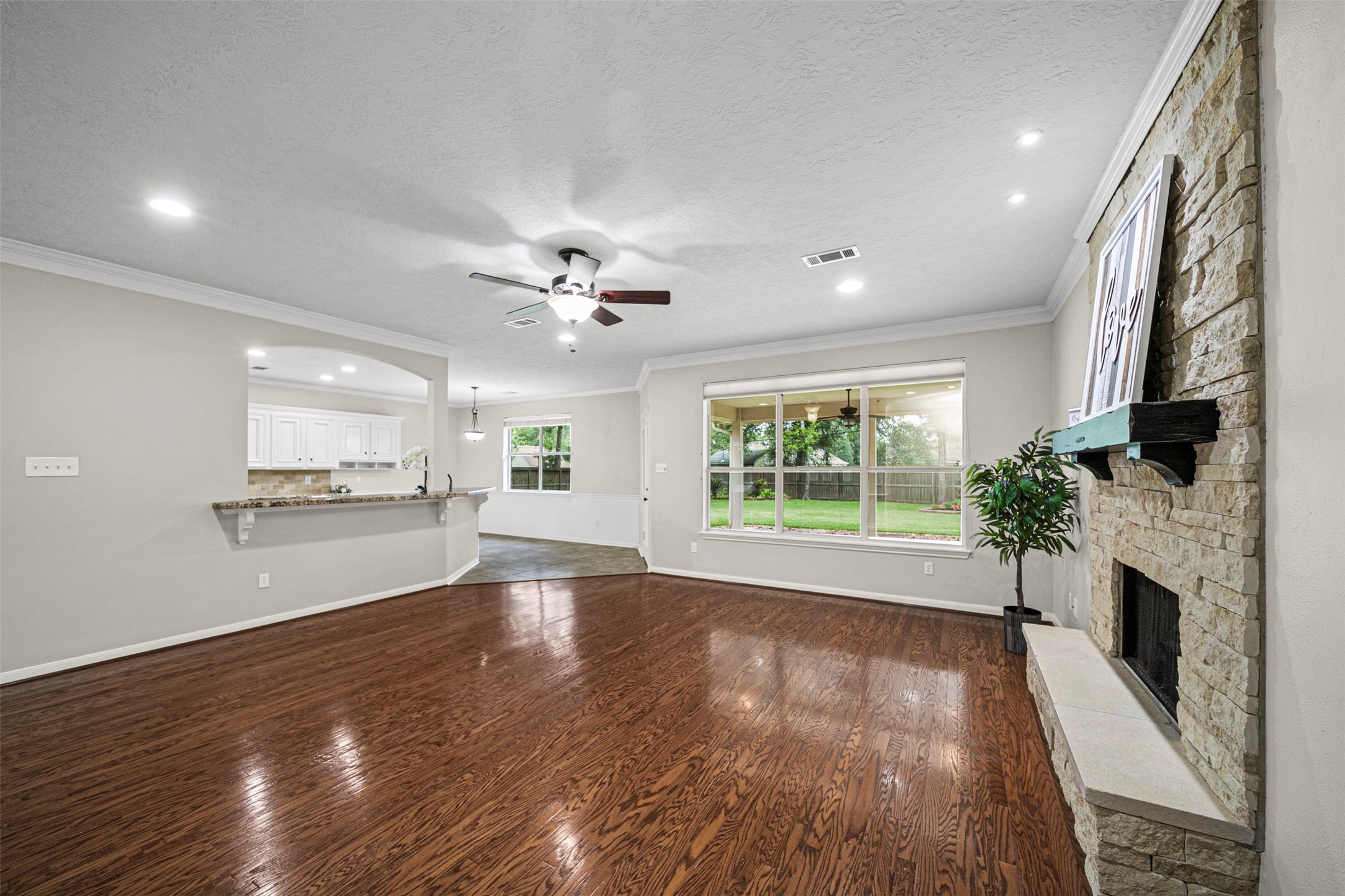 2452 Ripplewood Drive Conroe, TX 77384 - Photo 8 of 31 a view of an empty room with wooden floor fireplace and a window