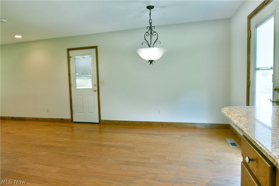 754 Warner Road Hubbard, OH 44425 - Photo 19 of 46 Spacious interior featuring wood-finish flooring, a white paneled door with glass insert, recessed lighting, and a decorative ceiling light fixture