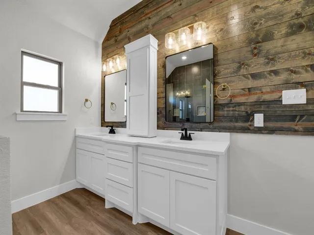 a bathroom with a double vanity sink mirror and bathtub
