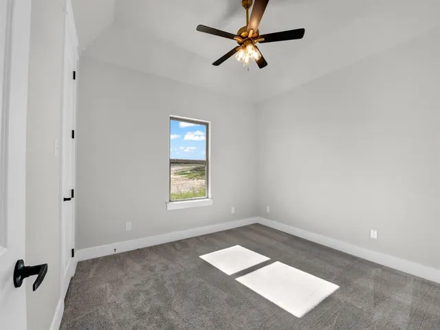 an empty room with a window and a fan