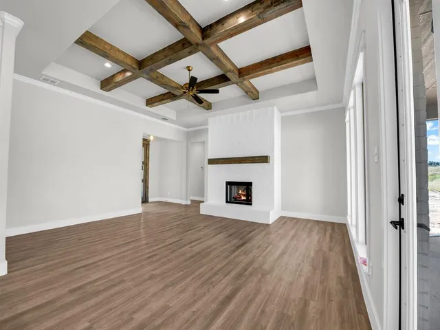 a view of empty room with wooden floor and fireplace