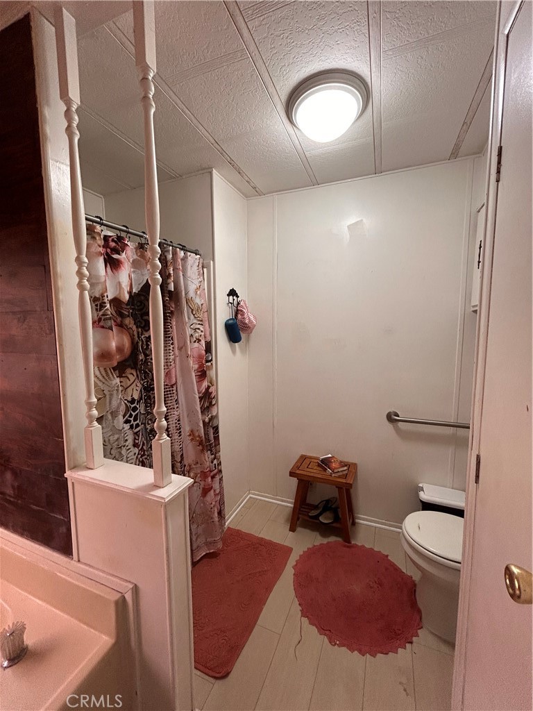 31816 Avenue E, Unit 135 Yucaipa, CA 92399 - Photo 10 of 12 a bathroom with a sink mirror vanity and toilet