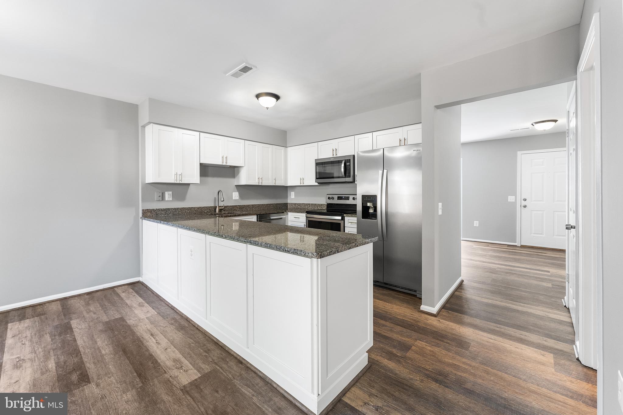 892 Smartts Lane Northeast Leesburg, VA 20176 - Photo 7 of 23 a kitchen with granite countertop a refrigerator and a stove top oven