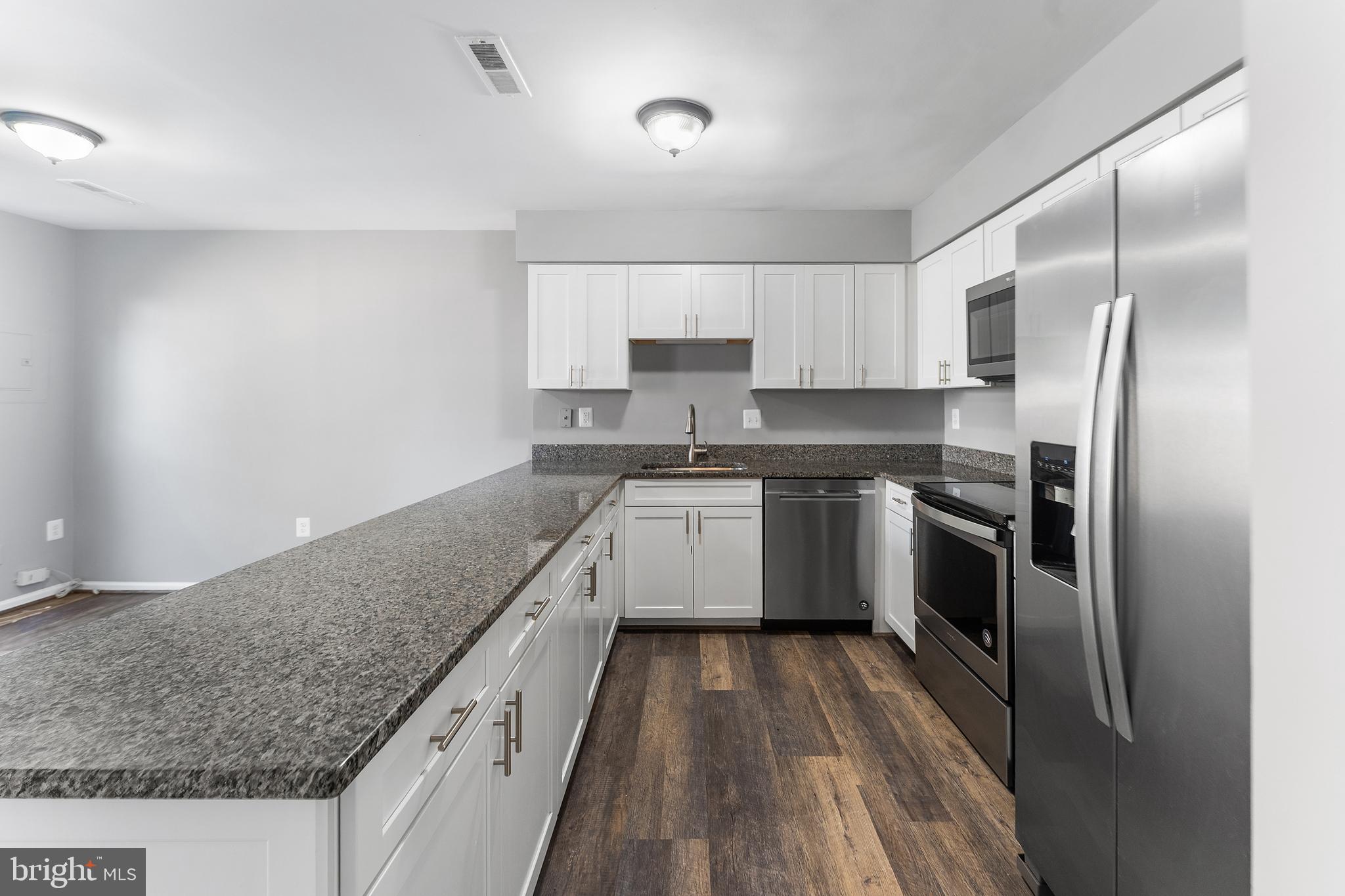 892 Smartts Lane Northeast Leesburg, VA 20176 - Photo 8 of 23 a kitchen with stainless steel appliances granite countertop a refrigerator a sink dishwasher a stove and white countertops with wooden floor