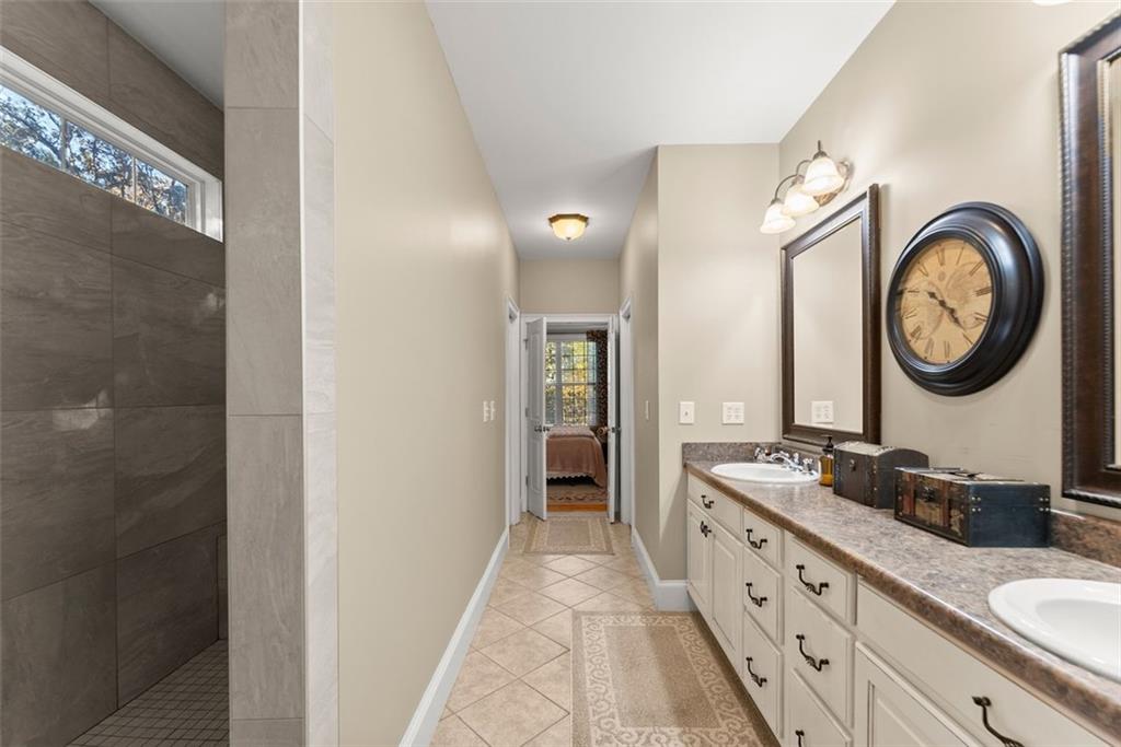 7269 Sloan Stephens Road Alto, GA 30510 - Photo 27 of 70 a bathroom with a granite countertop double vanity sink and a mirror