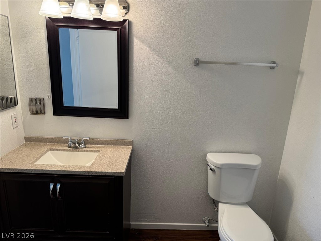 7885 West Flamingo Road, Unit 2171 Las Vegas, NV 89147 - Photo 12 of 22 A well-appointed bathroom features a dark wood vanity with a light-colored countertop and a mirror.