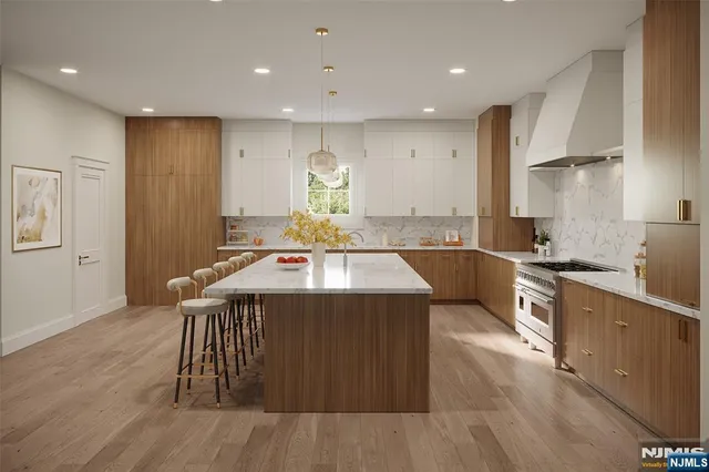 a kitchen with stainless steel appliances granite countertop a sink a stove and a wooden floors