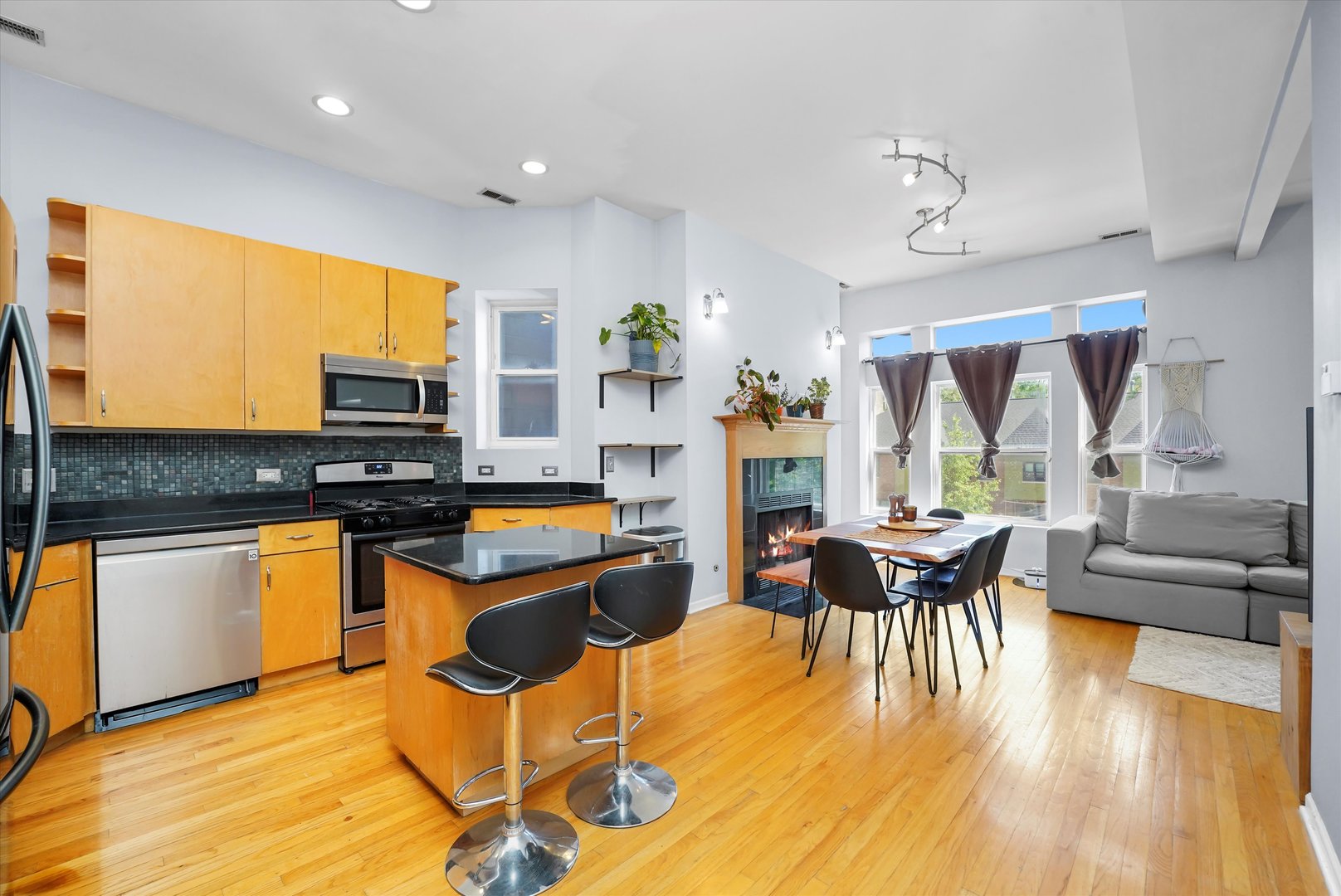 2744 West Haddon Avenue, Unit 2 Chicago, IL 60622 - Photo 2 of 22 a kitchen with stainless steel appliances granite countertop a stove top oven a sink dishwasher a dining table and chairs with wooden floor