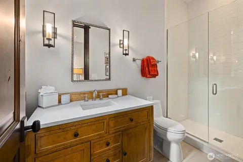 a bathroom with a sink vanity mirror and toilet