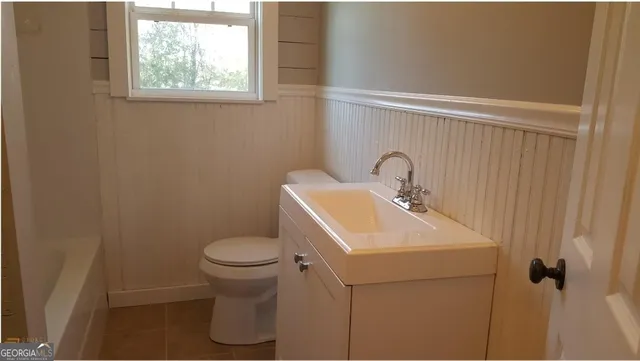 a bathroom with a sink toilet and a mirror