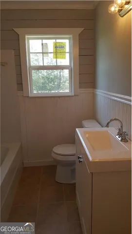 a bathroom with a sink a toilet and a window