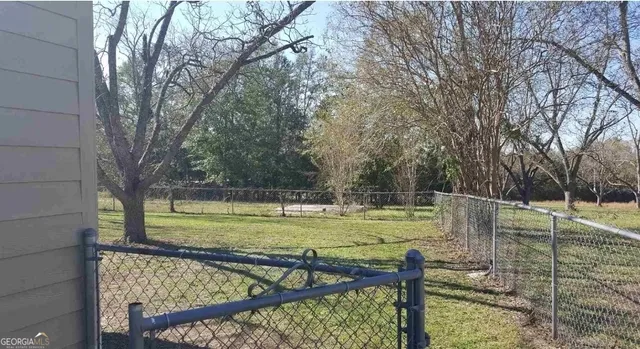 a view of a swimming pool with a patio and a yard