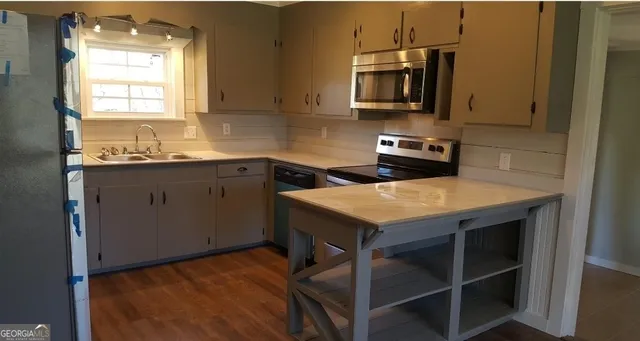 a kitchen with a stove a sink and a microwave