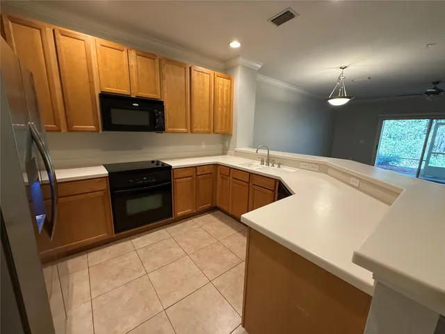 a kitchen with stainless steel appliances granite countertop a sink a stove and a refrigerator