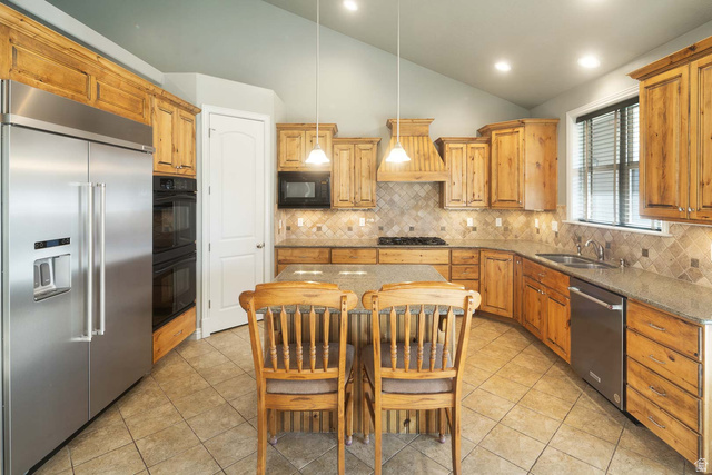 1997 West Cres Drive Mapleton, UT 84664 - Photo 11 of 35 Kitchen with black appliances, vaulted ceiling, dark stone countertops, hanging light fixtures, and light tile patterned floors