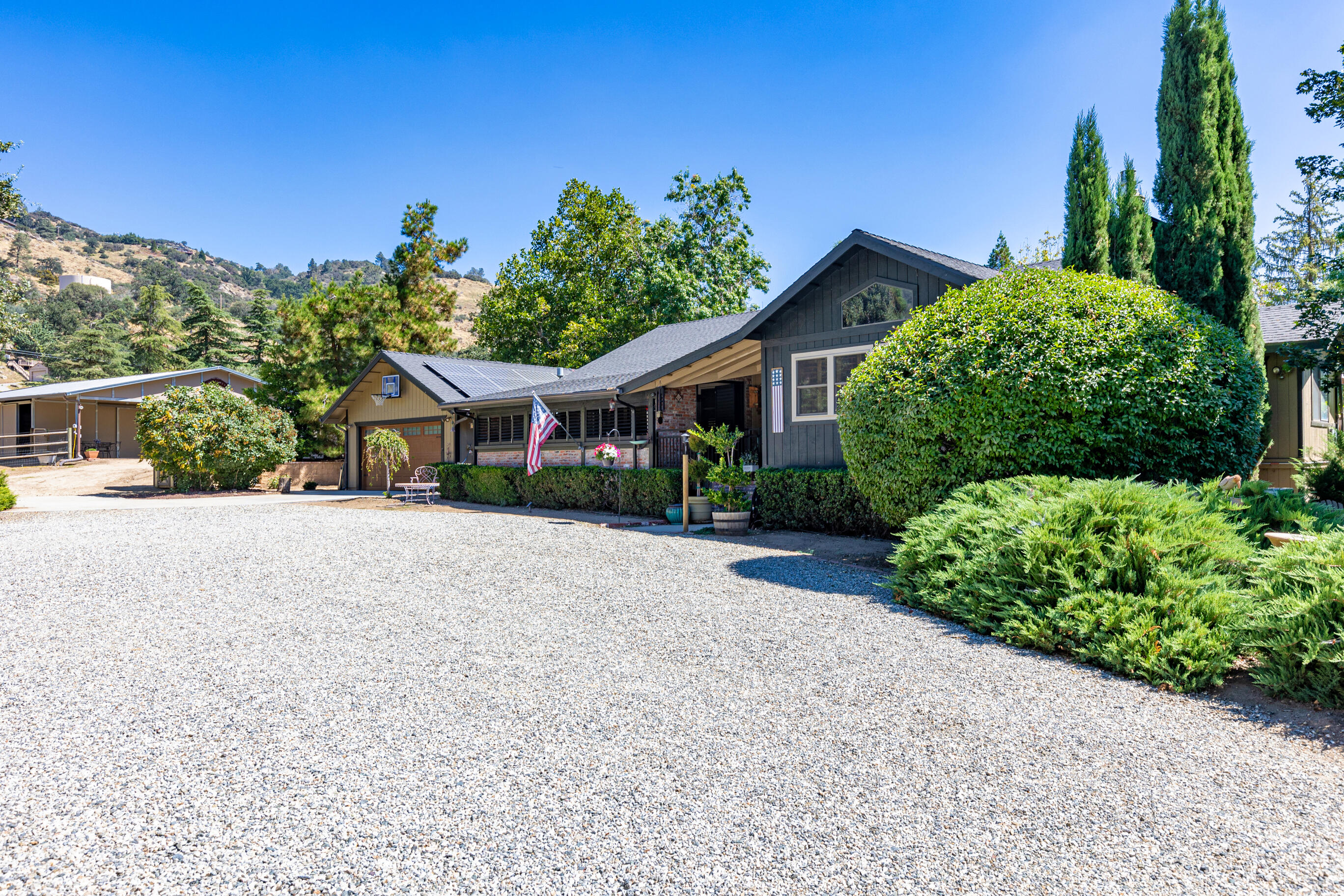 26901 Bear Valley Road Tehachapi, CA 93561 - Photo 2 of 62 a front view of a house with a yard and potted plants
