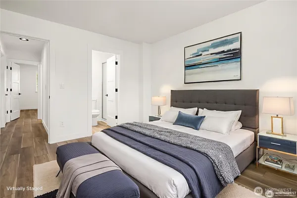 a bedroom with a large bed and a painting on the wall