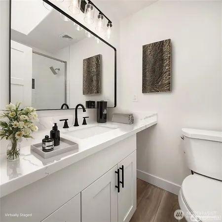 a bathroom with a toilet a sink and mirror
