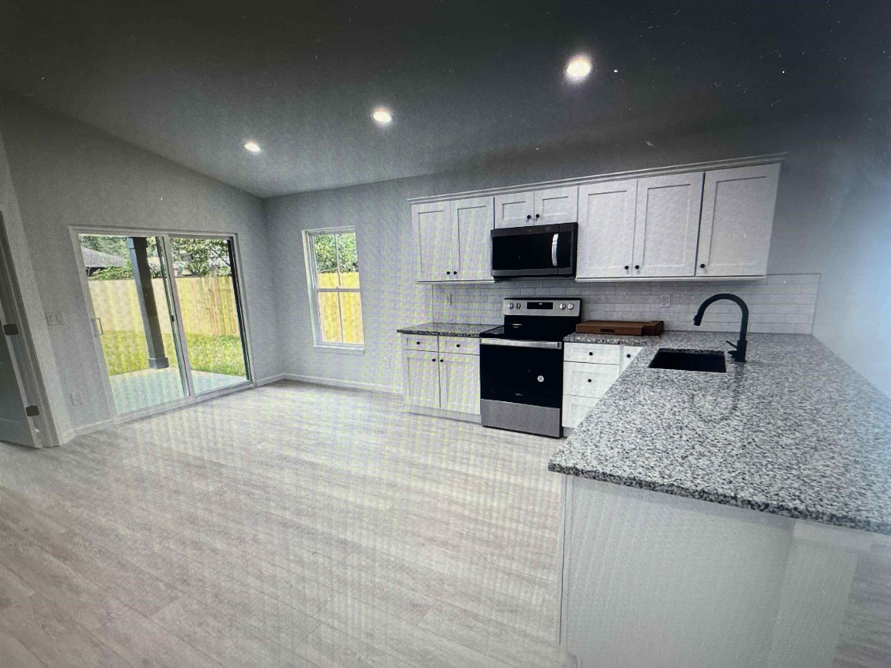 231 Monterey Avenue St. Augustine, FL 32084 - Photo 3 of 15 a kitchen with granite countertop a sink and a stove top oven