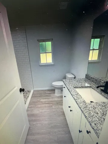 a bathroom with a granite countertop sink and a mirror