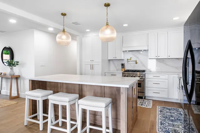 a kitchen with stainless steel appliances a stove a sink island and a refrigerator