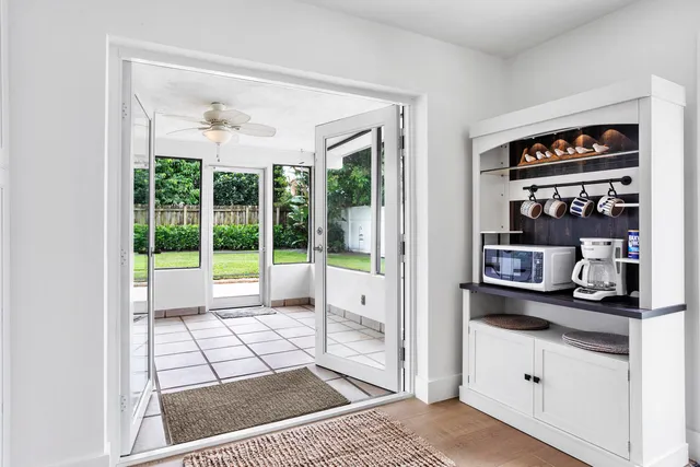 a living room with stainless steel appliances furniture and a floor to ceiling window