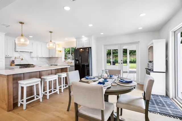 a kitchen with a dining table chairs and refrigerator
