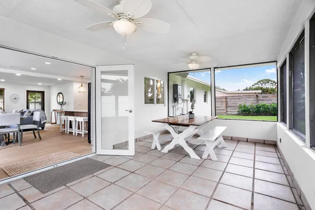 a living room with chairs a table and a large window