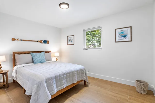 a bedroom with a bed and painting on the wall