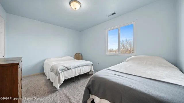 a bedroom with two beds and a window