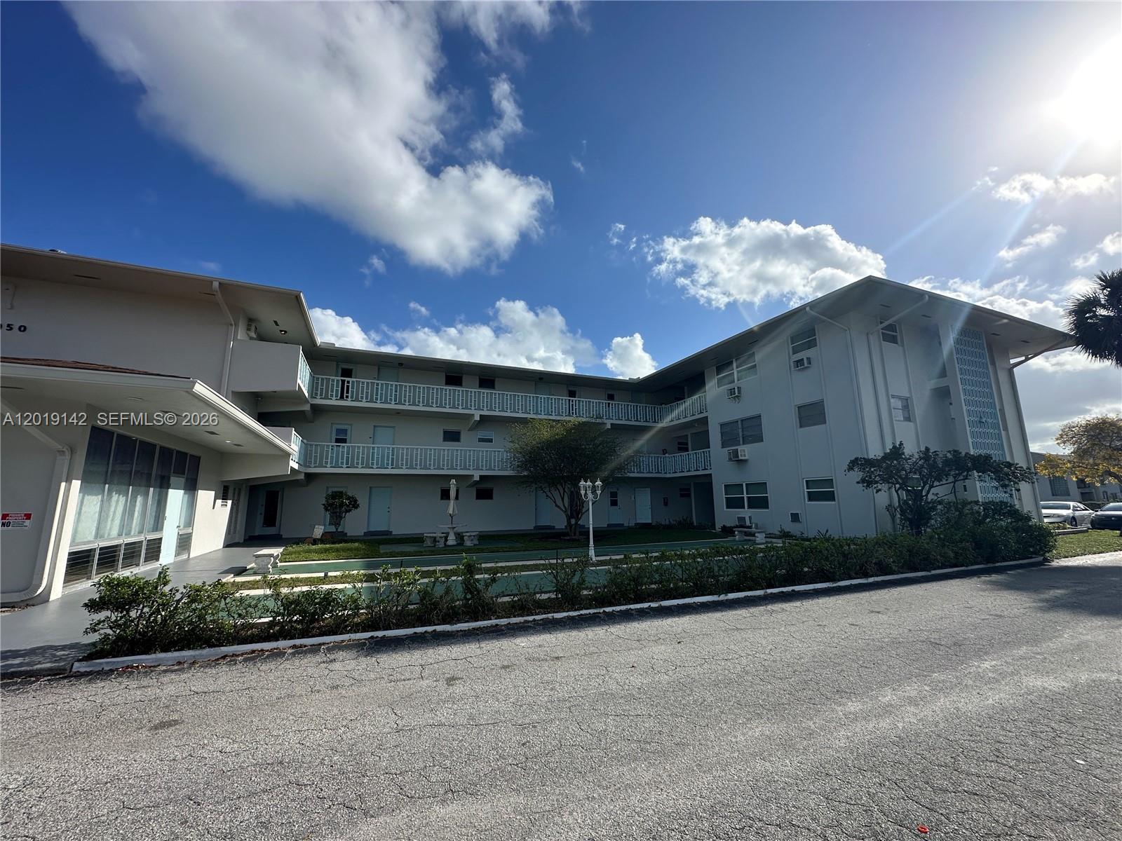 1050 East Sample Road, Unit 208 Pompano Beach, FL 33064 - Photo 1 of 9 a view of a house next to a yard