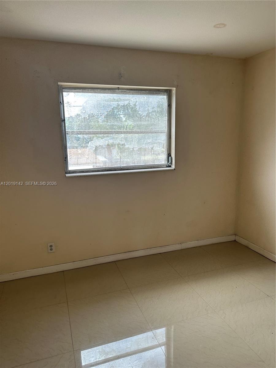 1050 East Sample Road, Unit 208 Pompano Beach, FL 33064 - Photo 4 of 9 a view of a small space with wooden floor and a window