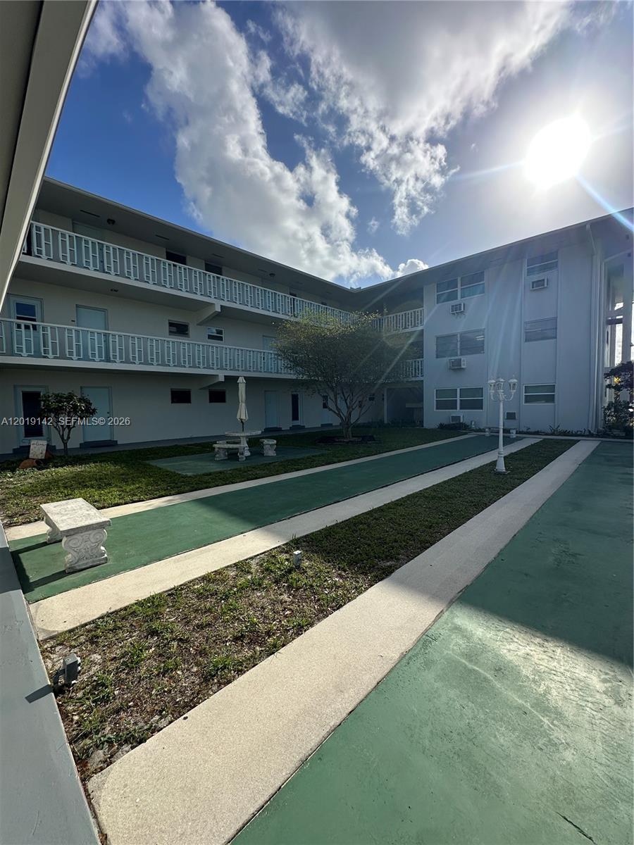 1050 East Sample Road, Unit 208 Pompano Beach, FL 33064 - Photo 7 of 9 a view of a house with a yard