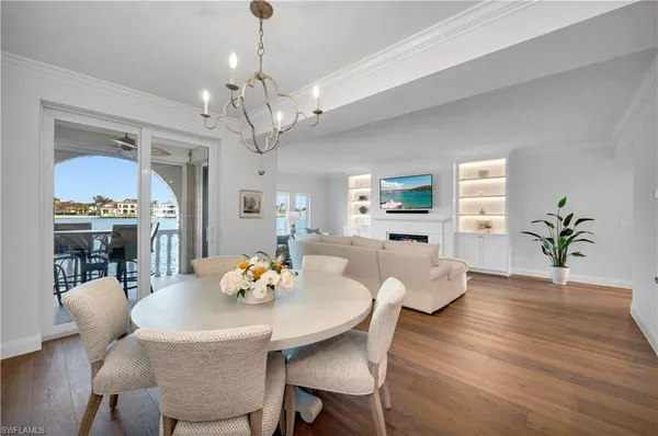a view of a dining room with furniture a chandelier and wooden floor