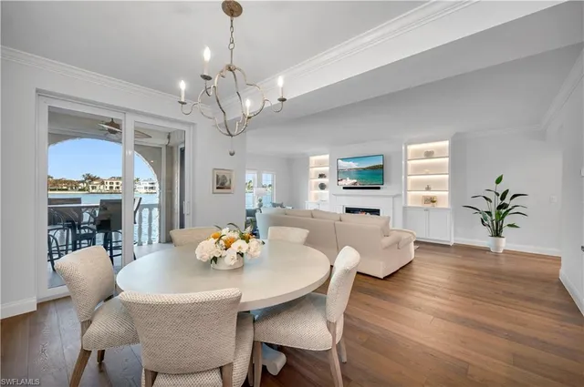 a view of a dining room with furniture a chandelier and wooden floor