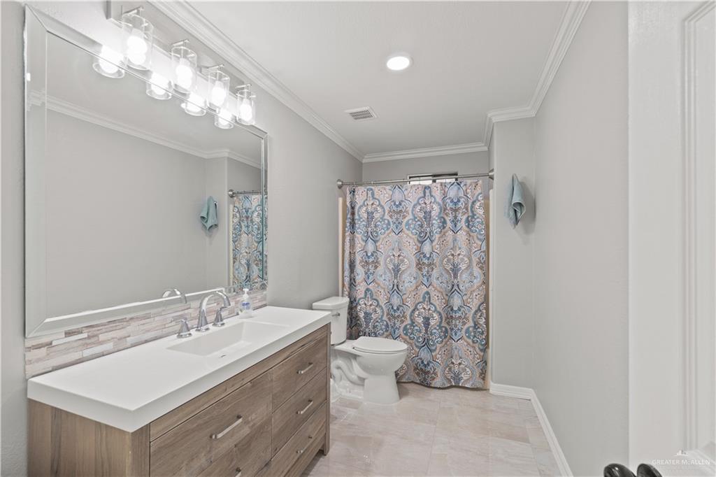 9230 North Moorefield Road Mission, TX 78574 - Photo 11 of 27 a spacious bathroom with a double vanity sink toilet and a mirror