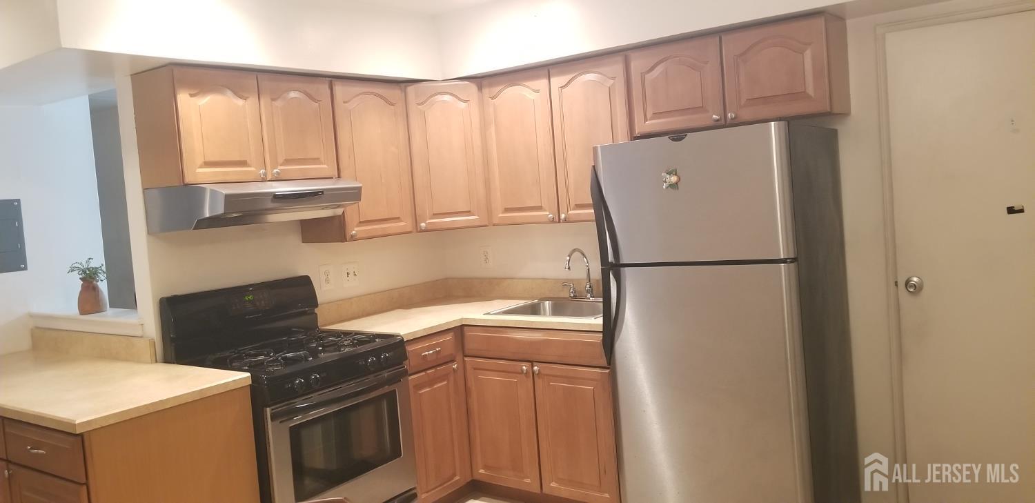 27 Judson Street, Unit 13B Edison, NJ 08837 - Photo 18 of 21 a kitchen with a refrigerator sink stove and cabinets