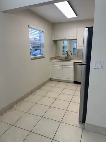 a kitchen with a refrigerator a stove top oven and cabinets