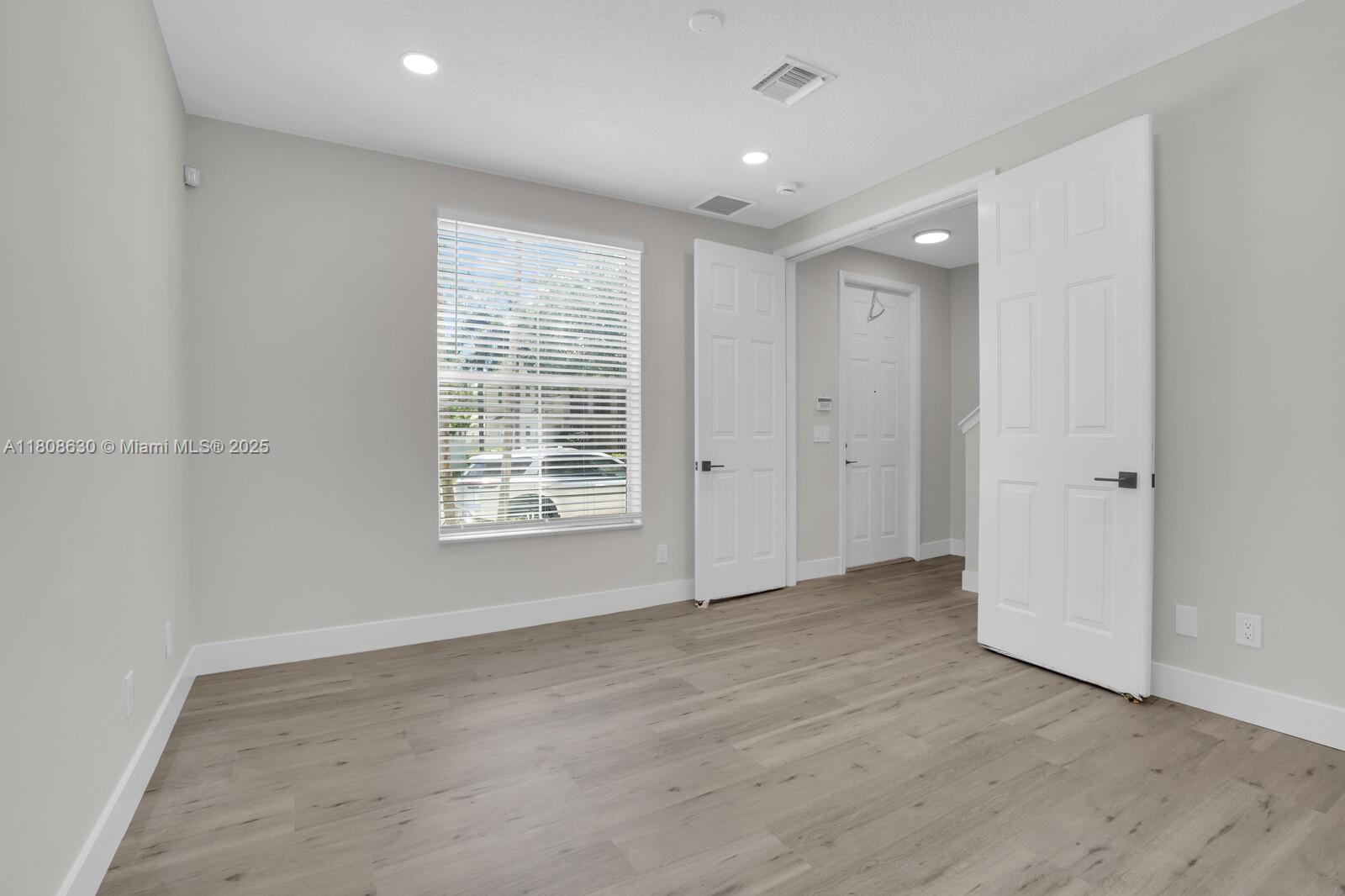4123 Parkside Drive Jupiter, FL 33458 - Photo 15 of 39 a view of an empty room with wooden floor and a window