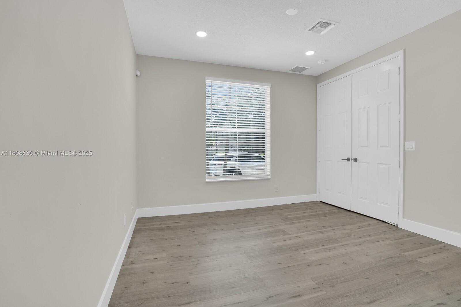 4123 Parkside Drive Jupiter, FL 33458 - Photo 16 of 39 a view of an empty room with wooden floor and a window