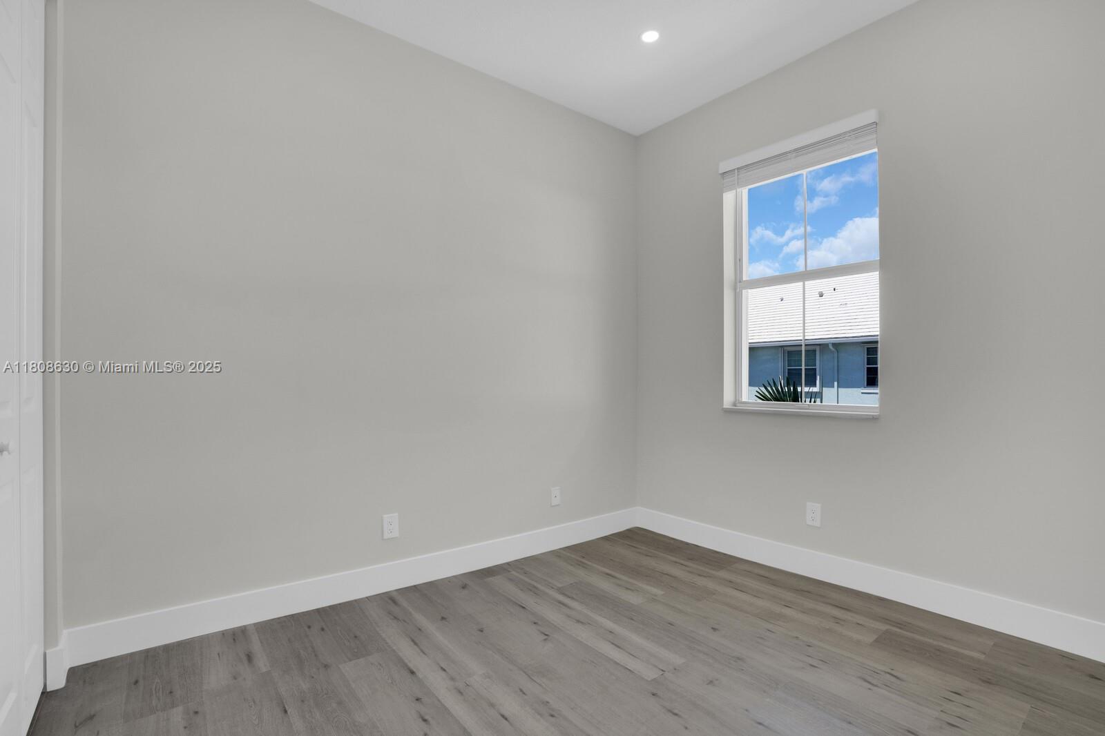 4123 Parkside Drive Jupiter, FL 33458 - Photo 19 of 39 a view of an empty room with wooden floor and a window