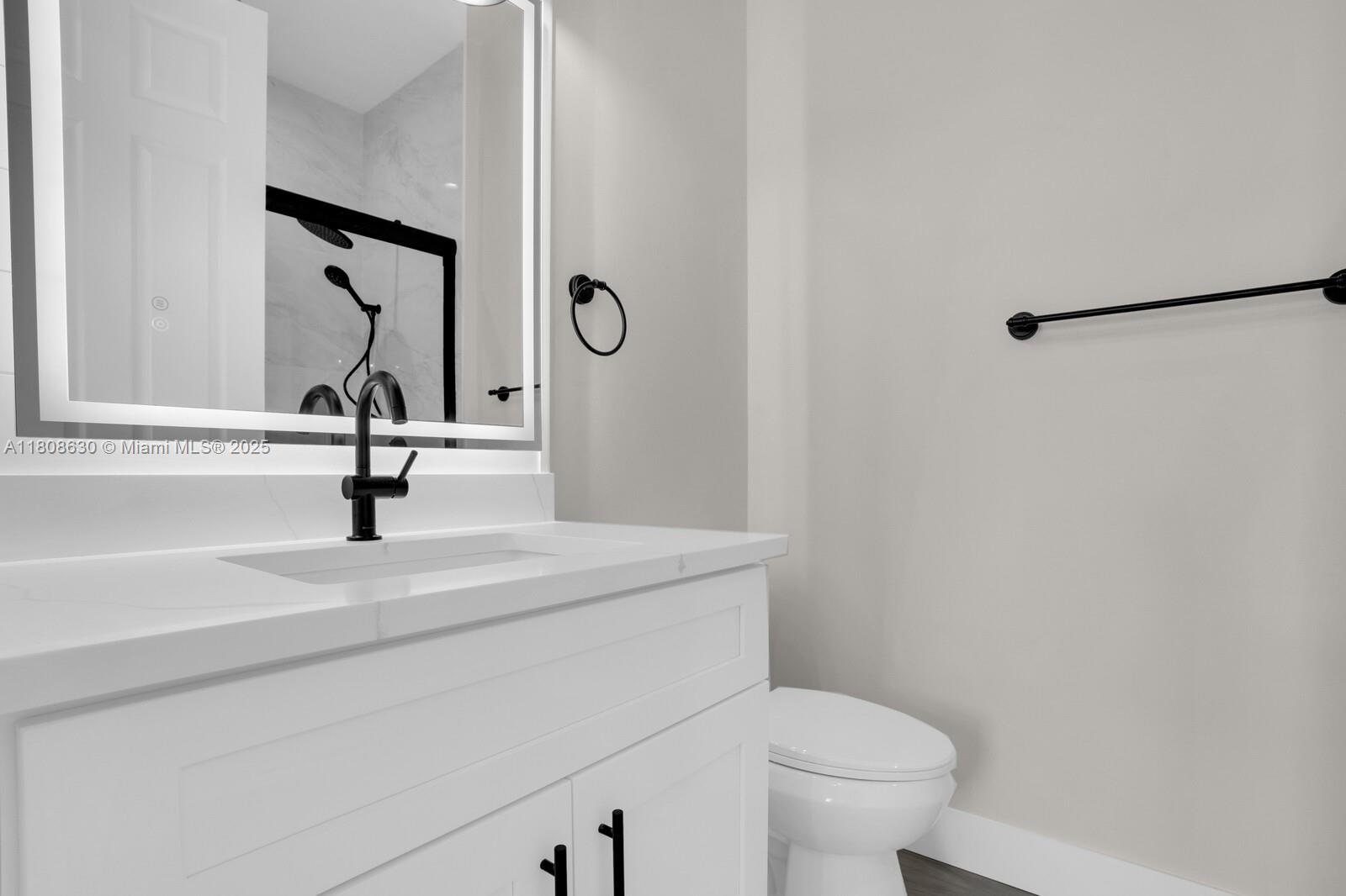 4123 Parkside Drive Jupiter, FL 33458 - Photo 25 of 39 a bathroom with a sink a toilet and a mirror